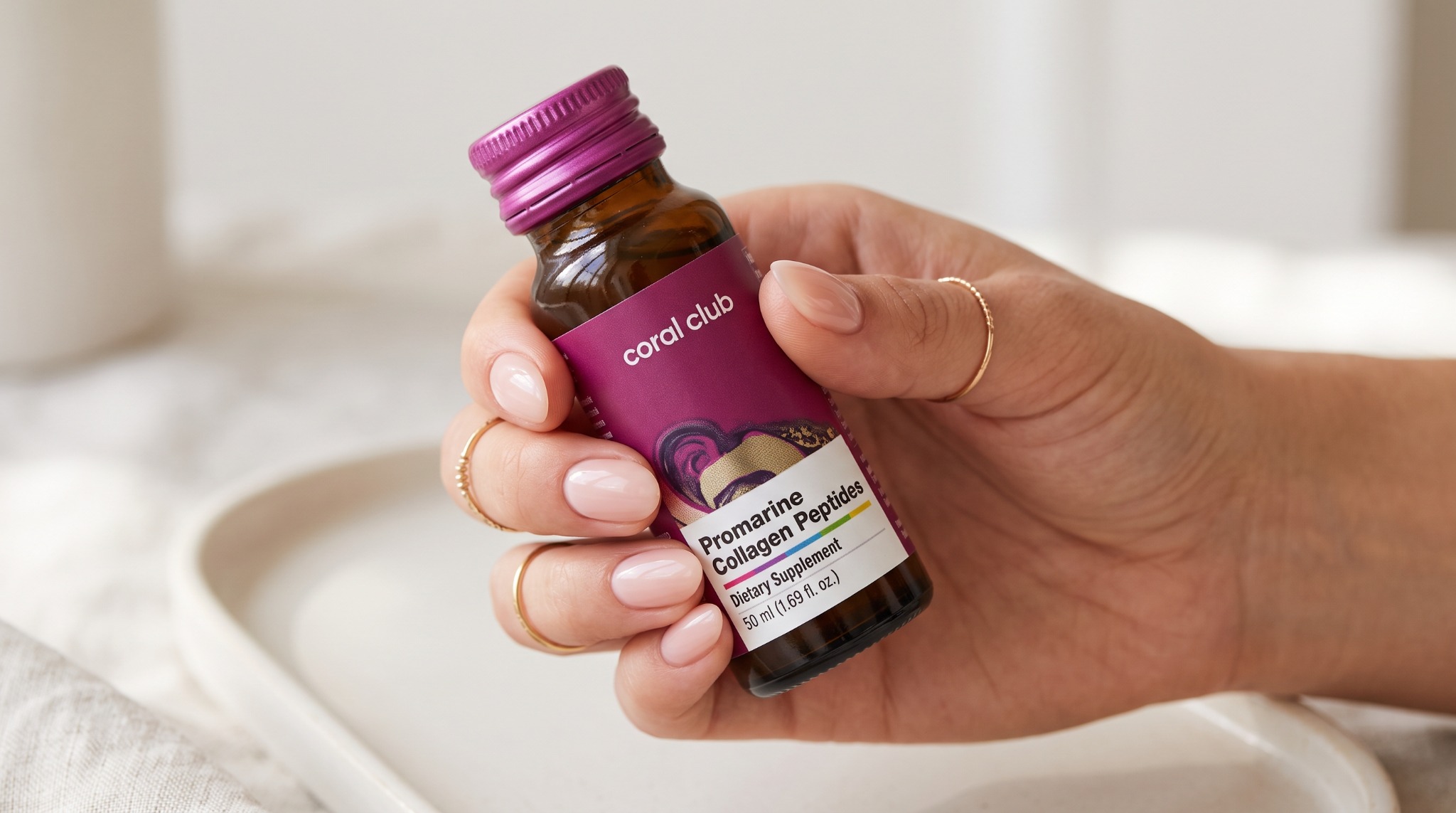 Promarine Collagen Peptides bottle held in a manicured hand